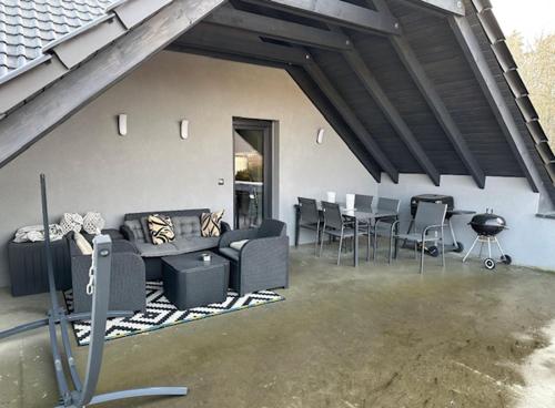 salon z kanapą, stołem i krzesłami w obiekcie Apartament nad Jeziorem w mieście Skorochow