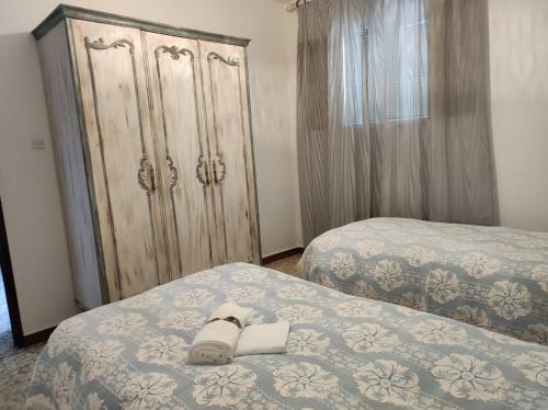 um quarto com 2 camas e uma grande cómoda em Casa Rural Villagarcia em El Real de la Jara