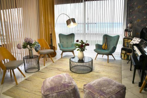 a living room with chairs and a table and a piano at Klinakis Beach Hotel in Chania Town