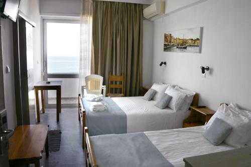a hotel room with two beds and a window at Klinakis Beach Hotel in Chania Town