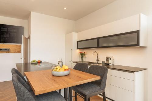 a kitchen with a table with a bowl of fruit on it at Hotel ChiemseePanorama in Gstadt am Chiemsee