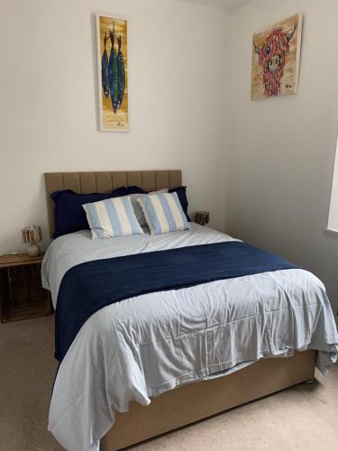 a bedroom with a bed with blue and white sheets at ARDUTHIE STREET in Stonehaven