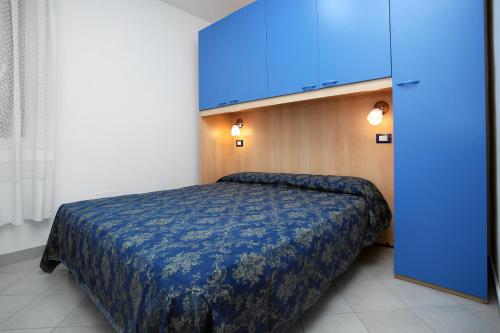 ein Schlafzimmer mit einem blauen Bett und einem blauen Schrank in der Unterkunft Residence El Patio in Rosolina Mare