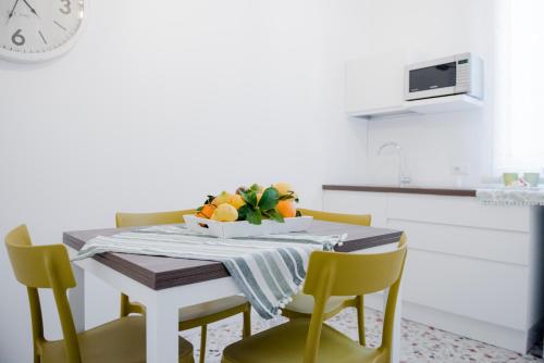 - une table à manger avec des chaises et une corbeille de fruits dans l'établissement CIELO D' ALCAMO, à Alcamo