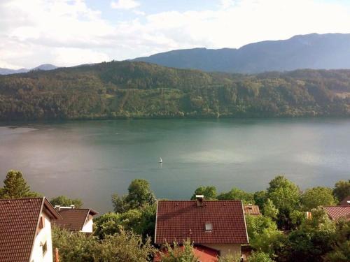 uma vista para um lago com casas e montanhas em Haus Kraller-Urlaub mit Seeblick em Millstatt