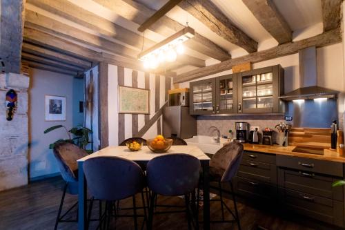 een keuken met een tafel en stoelen in een kamer bij La Tour aux Grains chambres autonomes in Romorantin