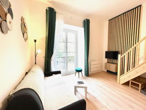 salon z kanapą i oknem w obiekcie Saint Leonard w mieście Nantes