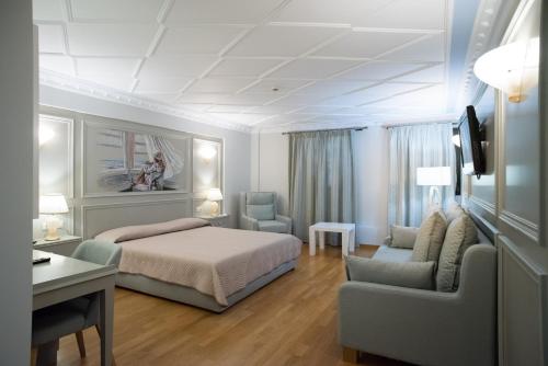 een slaapkamer met een bed, een stoel en een bureau bij Byzantino Hotel in Patra