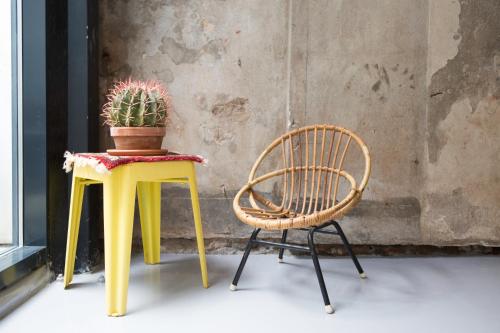 a chair and a table with a potted plant on it at Hotel Zilt Studio's in Vlissingen
