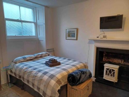 a bedroom with a bed with a tv and a fireplace at The Wee Room -Stay Where All St Andrews is on the Doorstep! in Fife