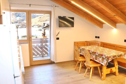 a dining room with a table and chairs and a window at Casa Severina in Livigno