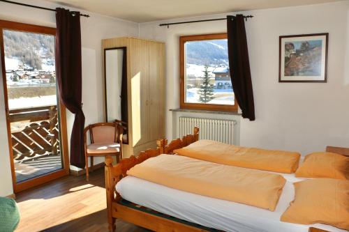 a bedroom with a bed and a large window at Casa Severina in Livigno