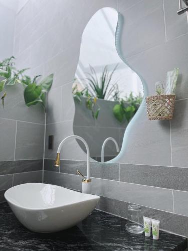 a bathroom with a white sink and some plants at Sea House Hotels and Apartments in Vung Tau