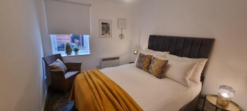 una camera con un letto e una sedia e una finestra di Merchantcityflat a Glasgow