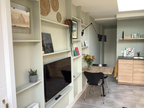 een woonkamer met een bureau en een grote spiegel bij Atelier Zonnehoek in Bergen