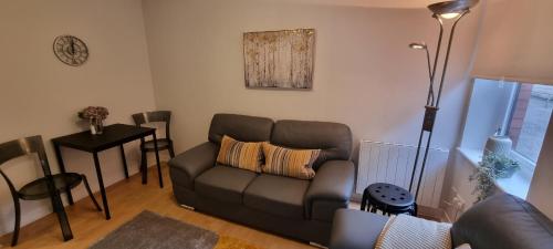 un salon avec un canapé et une table dans l'établissement Merchantcityflat, à Glasgow