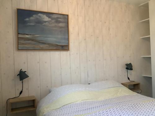 1 dormitorio con 1 cama y una pintura en la pared en Atelier Zonnehoek en Bergen