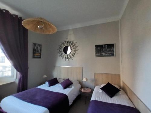 - une chambre avec 2 lits et un miroir mural dans l'établissement Au Moulin d'Or, à Lille