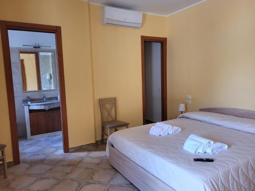 um quarto com uma cama e uma casa de banho com um lavatório em ALLOGGIO TURISTICO MAGNIFICO ALESSANDRO VALLE BERNARDO 04025 LENOLA LT CIR 19063 nei pressi di 04022 FONDI LT em Lenola