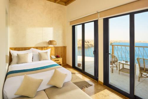 a bedroom with a bed and a view of the ocean at Benben by Dhara Hotels - Adults Only in Aswan