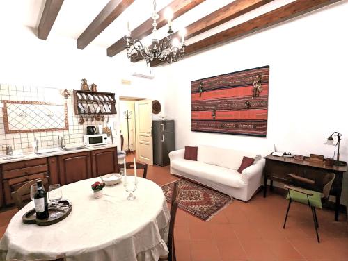 a kitchen and living room with a table and a couch at La Casa Delle Fate in Siracusa