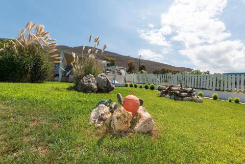 a statue of a pot sitting in the grass at Artemis Seafront Stone Studio in Petres