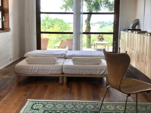 1 dormitorio con 2 camas y ventana grande en Stunning 21-Bed Cottage in La Sauvetat 2 houses, en La Sauvetat