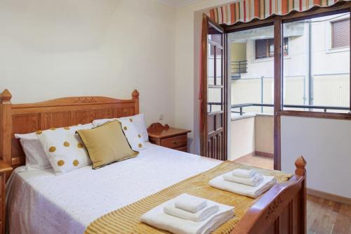 a bedroom with a bed with two towels on it at Apartamento Otoño - Apartamentos Nature in Cangas del Narcea