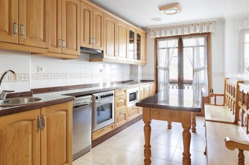 a kitchen with wooden cabinets and a black counter top at Apartamento Otoño - Apartamentos Nature in Cangas del Narcea