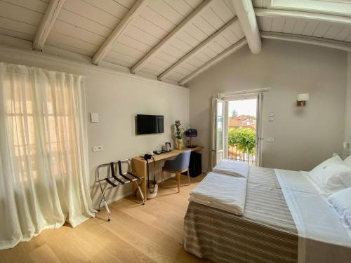 a bedroom with a bed and a desk and a television at La torre in Belgirate