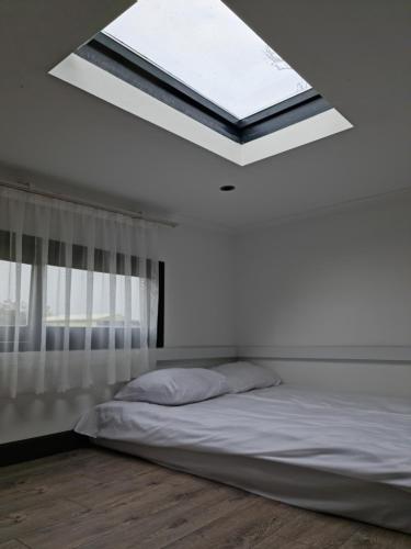 a bed in a white room with a skylight at Küçük Evler Tiny Houses in Istanbul