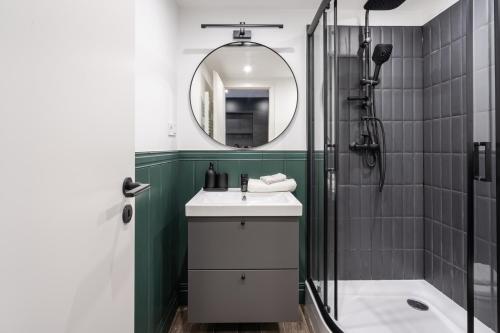 a bathroom with a sink and a shower with a mirror at E41- Boutique Apartments, Best Location, by BQA in Budapest