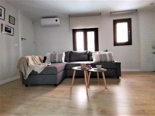 ein Wohnzimmer mit einem Sofa und einem Tisch in der Unterkunft Apartamento Ilarcuris con patio privado in Toledo