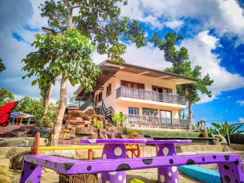 a house with a purple bridge in front of it at Mountaindew Garden and Pool in Roxas