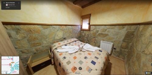 a bedroom with a bed in a stone wall at Finca La Ecarada. Férez (Albacete) in Férez
