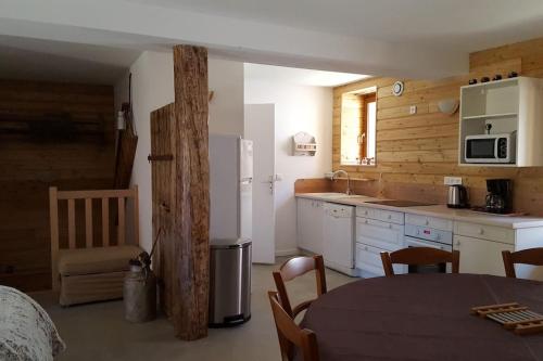 a kitchen with a table and a white refrigerator at Maison de village au cœur du hameau Les Marches à Orcières in Orcières
