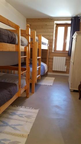 une chambre avec trois lits superposés et une fenêtre dans l'établissement Maison de village au cœur du hameau Les Marches à Orcières, à Orcières