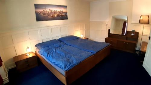 a bedroom with a bed with a blue comforter and two lamps at Ferienwohnung Rothorn Meiringen in Meiringen