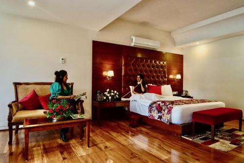 Dos mujeres en una habitación de hotel con cama y sofá en The Allure Grand Resort - A Riverside Resort and Spa, en Manali