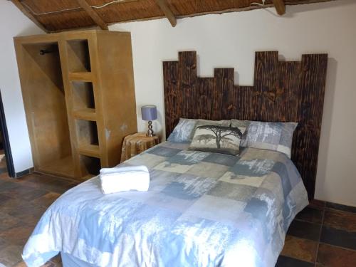 een slaapkamer met een groot bed met een houten hoofdeinde bij Unique Overnight Polokwane in Polokwane