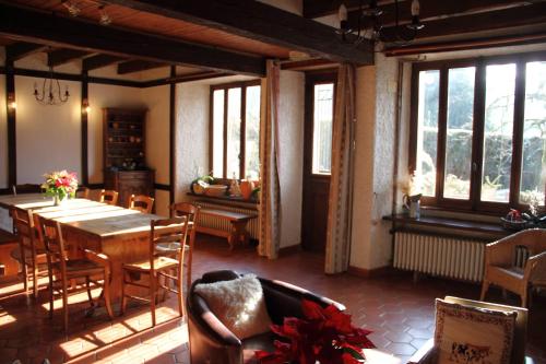 jadalnia ze stołem, krzesłami i oknami w obiekcie maison de marie w mieście Doussard