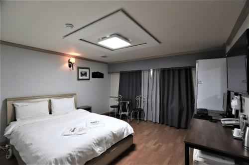 a hotel room with a bed and a desk at Hani Motel in Daejeon