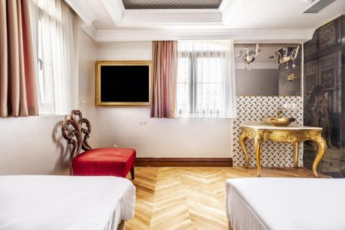 Habitación con 2 camas, mesa y TV. en Glamorous Authentic Studio in Üsküdar, en Estambul