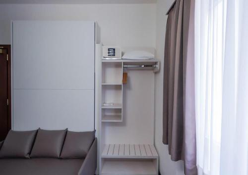 a living room with a couch and a window at Acquarello Swiss Quality Hotel in Lugano