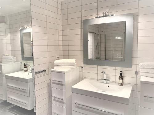 a white bathroom with two sinks and a mirror at Villa top view Tromsø in Tromsø