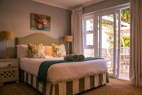 a bedroom with a bed and a sliding glass door at Hermanus Family Getaway - Near The Beach in Hermanus