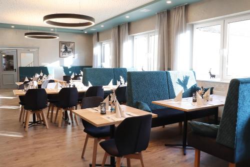 Hotel Restaurant Haus Zwicker في Bleialf: غرفة طعام مع طاولات وكراسي في مطعم