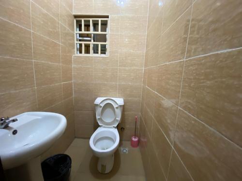 a bathroom with a white toilet and a sink at BLISS APARTMENTS Utako next to Wuse 2Abuja 1Bed35k 2Bed70k & 3Bed90k Flats in Abuja