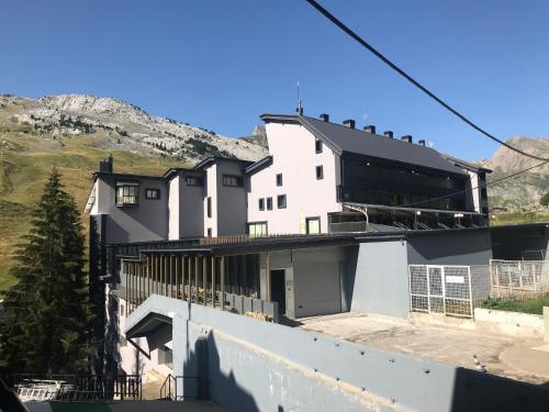 una casa blanca con una montaña en el fondo en Tobazo Candanchú pie de pista en Candanchú