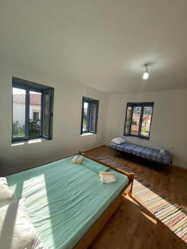 um quarto com uma cama grande e duas janelas em Kontias stonehouse 2 em Kondiás